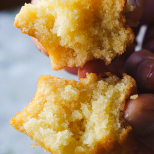 Hand splitting classic butter mochi showing chewy texture
