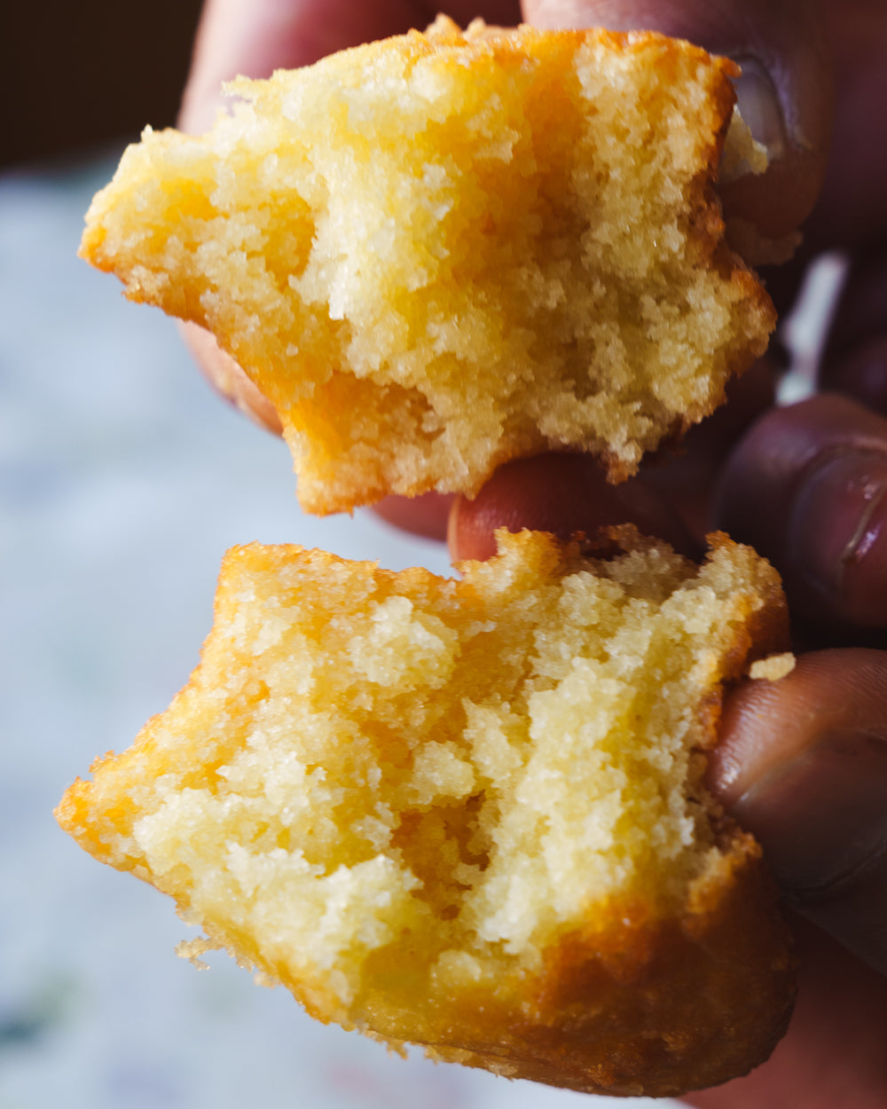 Hand splitting classic butter mochi showing chewy texture